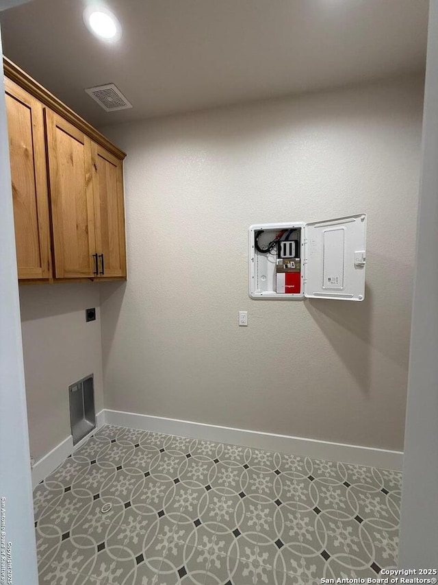 laundry room with cabinets, light tile patterned flooring, and electric dryer hookup