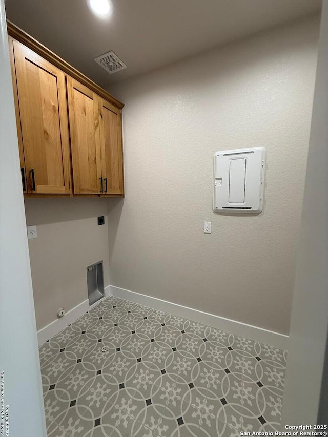 washroom with cabinets, gas dryer hookup, electric dryer hookup, and light tile patterned floors