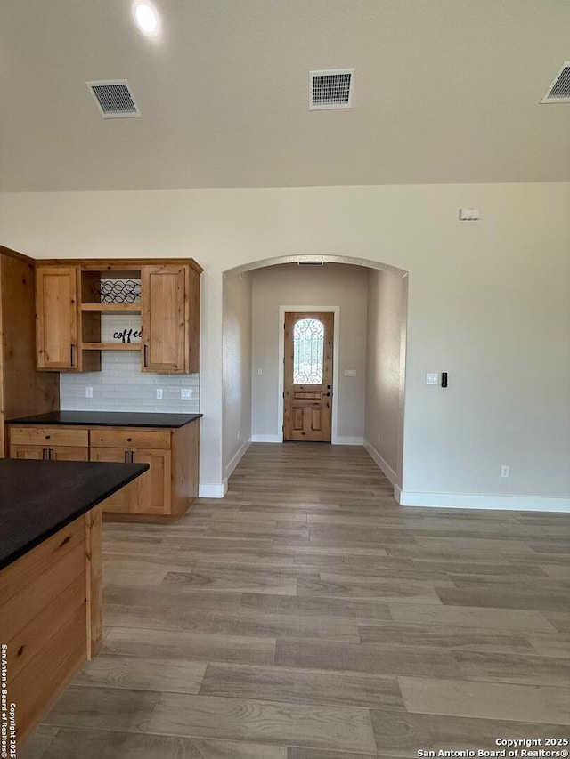 kitchen with light wood-type flooring and backsplash