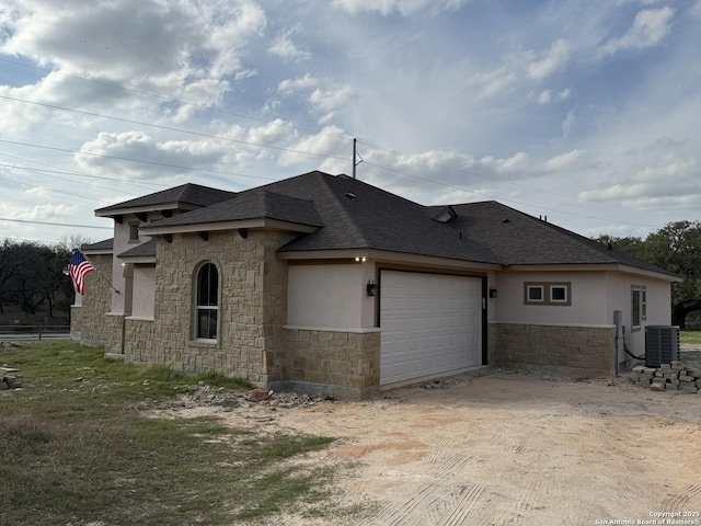 101 Hondo Rdg, La Vernia, TX 78121 - view of property exterior featuring stone siding, an attached garage, a shingled roof, and stucco siding