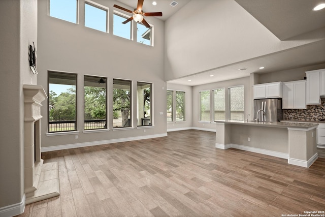 unfurnished living room featuring ceiling fan and light hardwood / wood-style floors