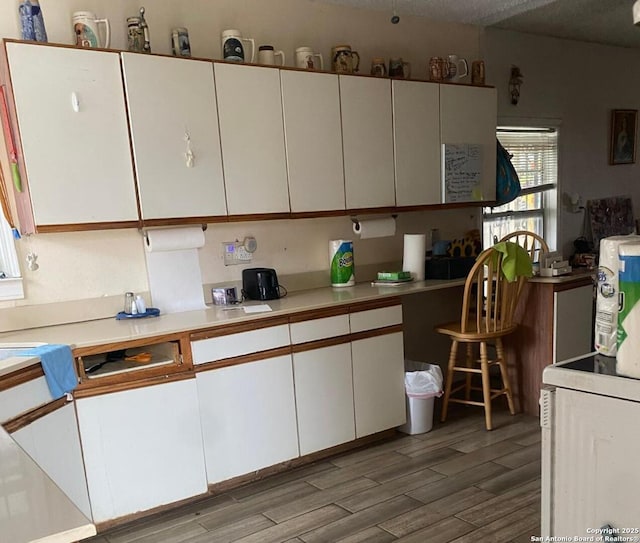 kitchen featuring hardwood / wood-style flooring and white cabinets