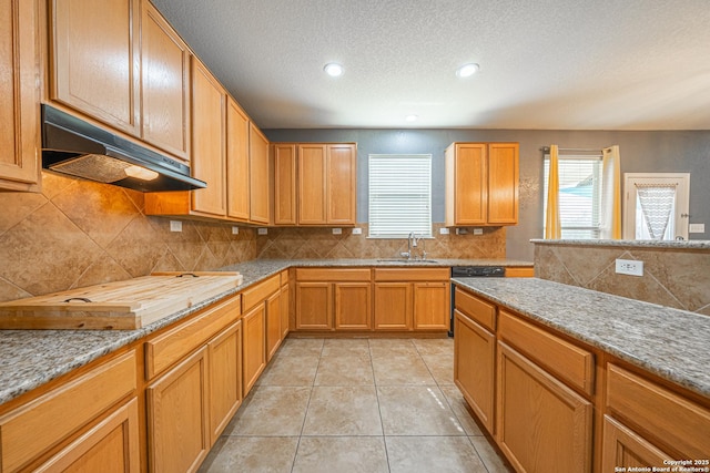 kitchen featuring black dishwasher, sink, light tile patterned floors, a textured ceiling, and decorative backsplash