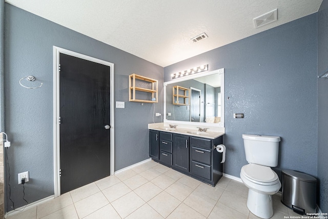 bathroom featuring tile patterned floors, toilet, vanity, and a textured ceiling