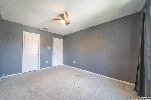 unfurnished bedroom featuring carpet, a textured ceiling, and ceiling fan