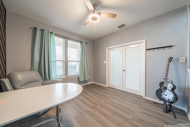 office area featuring ceiling fan, light hardwood / wood-style floors, and a textured ceiling