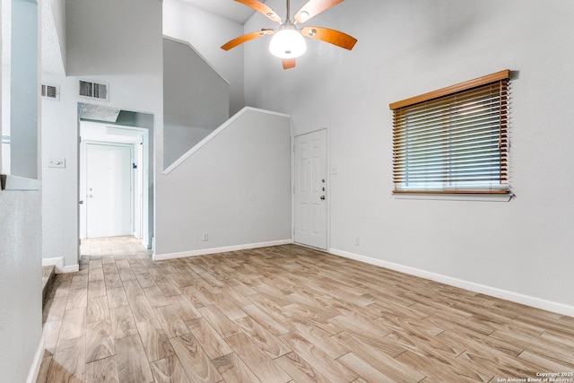 unfurnished living room featuring high vaulted ceiling, light hardwood / wood-style flooring, and ceiling fan