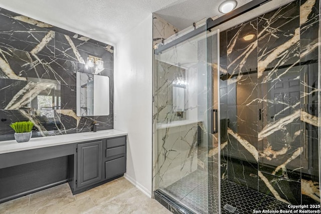 bathroom featuring an enclosed shower, vanity, and a textured ceiling