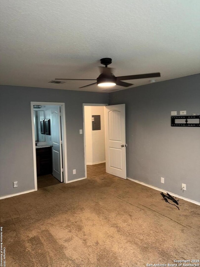 unfurnished bedroom with electric panel, carpet floors, and a textured ceiling