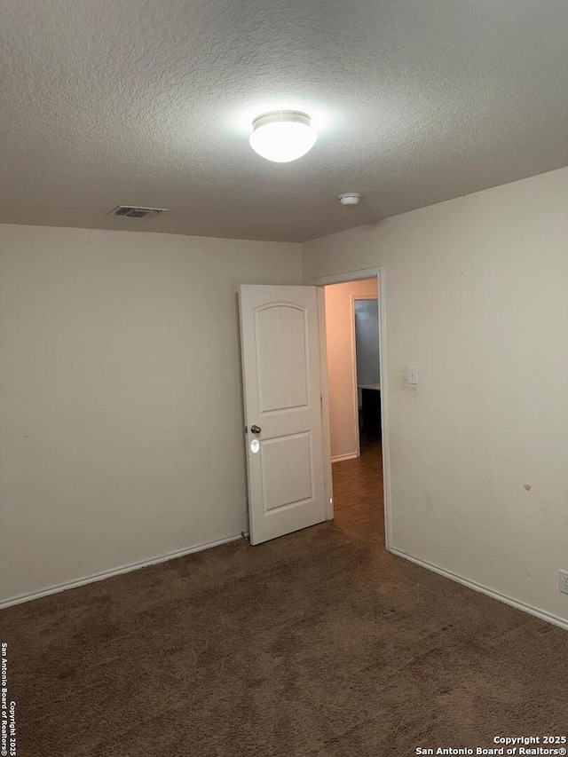 carpeted spare room featuring a textured ceiling