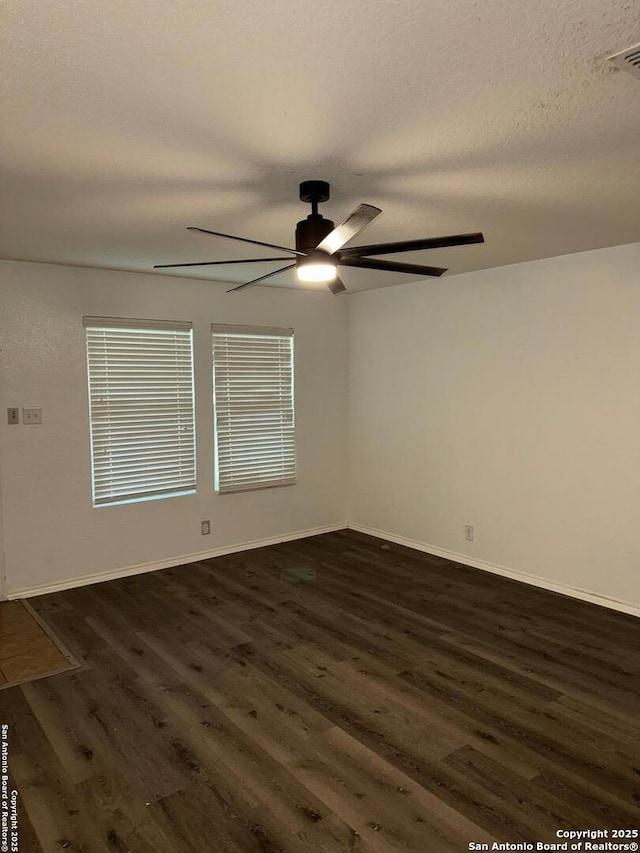 spare room featuring ceiling fan, dark wood-type flooring, and a textured ceiling