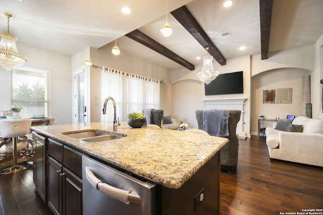 kitchen featuring a center island with sink, sink, light stone counters, dishwasher, and hanging light fixtures