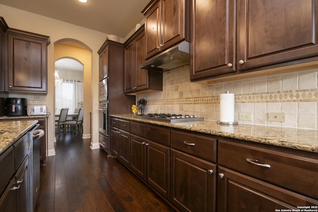 kitchen with backsplash, appliances with stainless steel finishes, and dark brown cabinetry