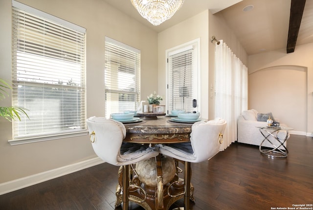 dining area with dark wood-type flooring, a notable chandelier, and beam ceiling