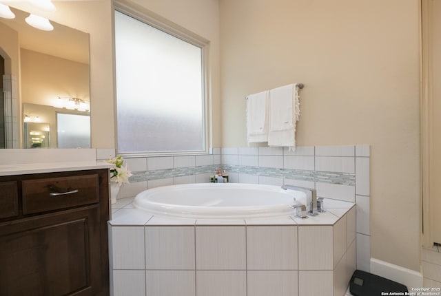 bathroom featuring vanity and a relaxing tiled tub