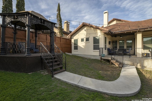 back of house featuring ceiling fan and a lawn