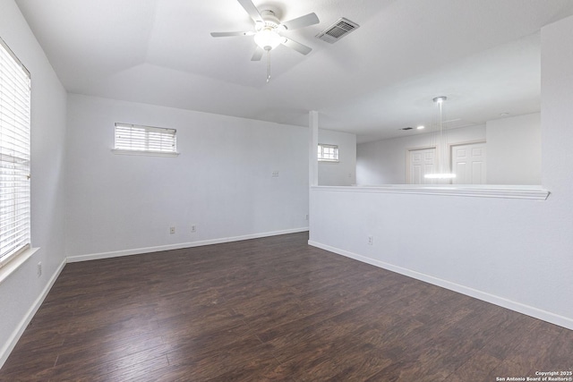 empty room with a wealth of natural light, ceiling fan, and dark hardwood / wood-style floors