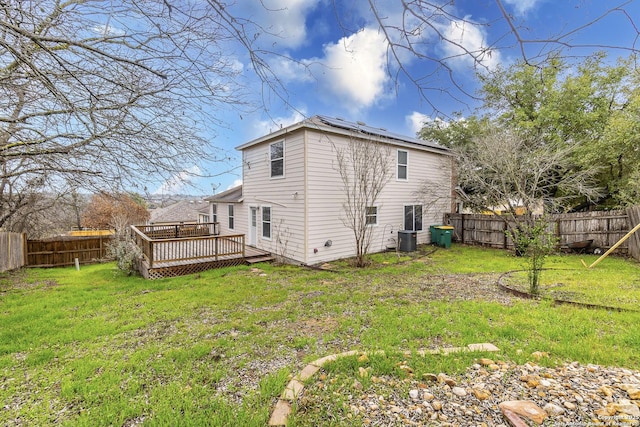 rear view of house with a lawn, a deck, and central air condition unit