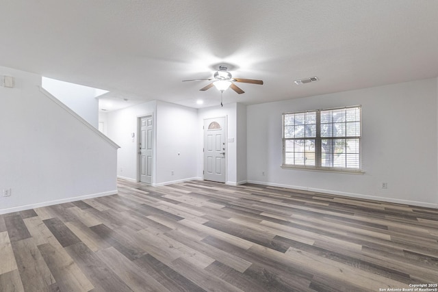 unfurnished living room with a textured ceiling, hardwood / wood-style flooring, and ceiling fan