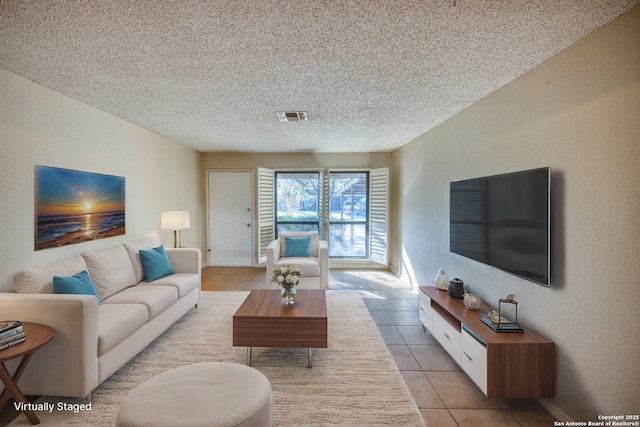 living room with light tile patterned floors and a textured ceiling