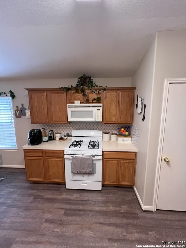 kitchen featuring white appliances, backsplash, and dark hardwood / wood-style floors