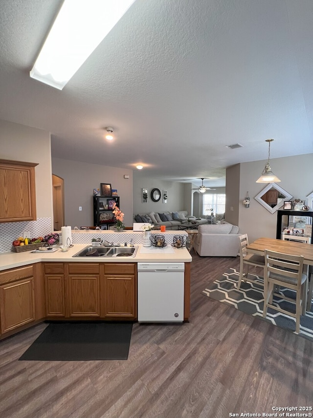 kitchen featuring hanging light fixtures, sink, ceiling fan, dishwasher, and dark hardwood / wood-style floors