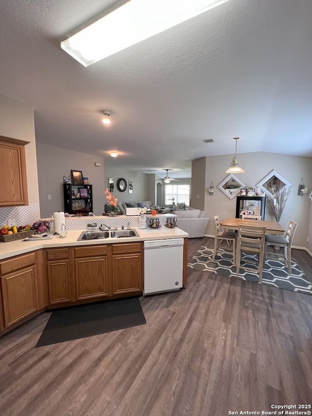 kitchen with hanging light fixtures, sink, white dishwasher, ceiling fan, and dark wood-type flooring