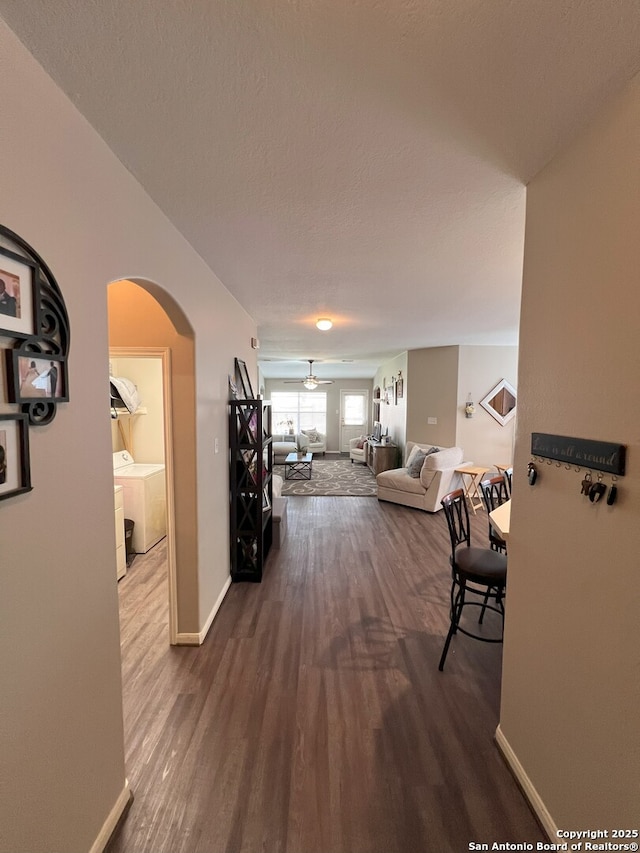 hallway with hardwood / wood-style floors, washing machine and dryer, and a textured ceiling