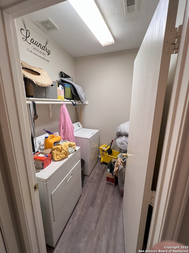 clothes washing area featuring independent washer and dryer, dark hardwood / wood-style floors, and a textured ceiling