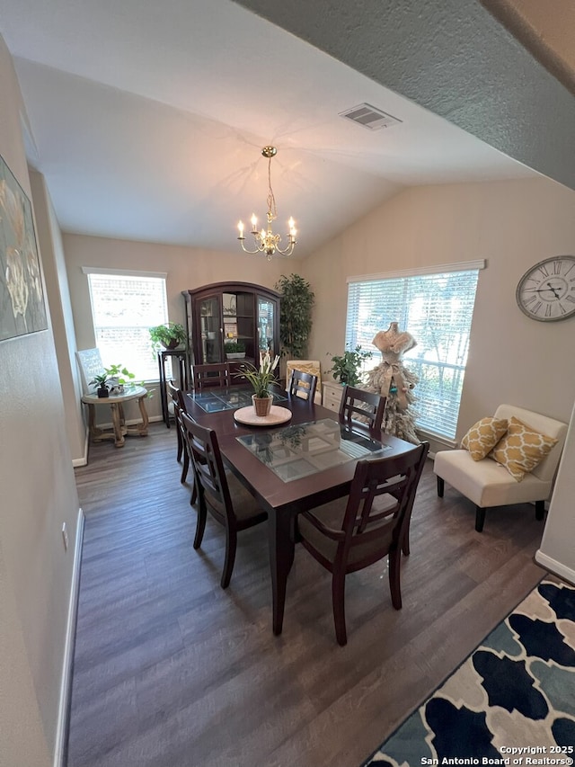 dining room featuring an inviting chandelier, dark hardwood / wood-style floors, and lofted ceiling