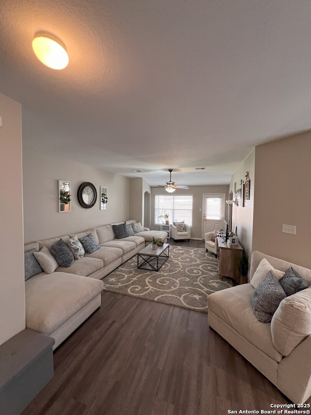 living room with dark hardwood / wood-style flooring and ceiling fan