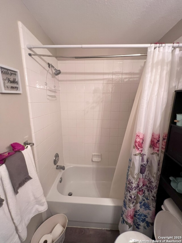 bathroom featuring shower / bath combination with curtain and a textured ceiling