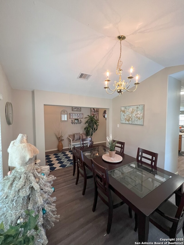 dining space featuring a chandelier, vaulted ceiling, and hardwood / wood-style floors