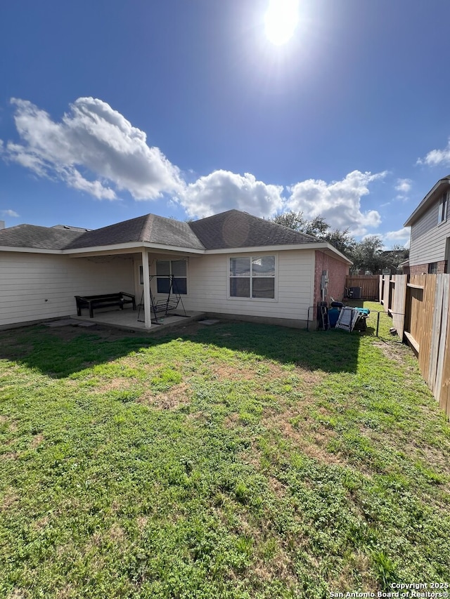 rear view of property with a patio and a yard