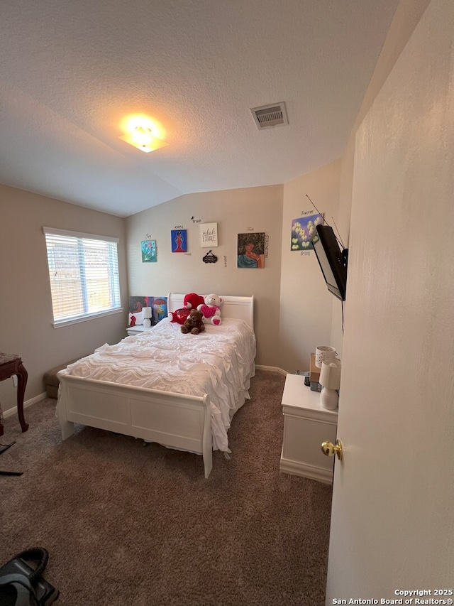 bedroom featuring dark carpet, a textured ceiling, and lofted ceiling