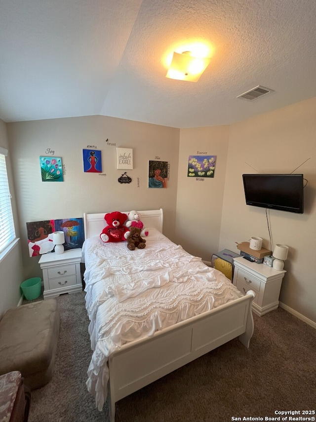 carpeted bedroom with a textured ceiling and vaulted ceiling