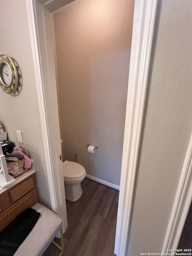 bathroom featuring toilet and wood-type flooring