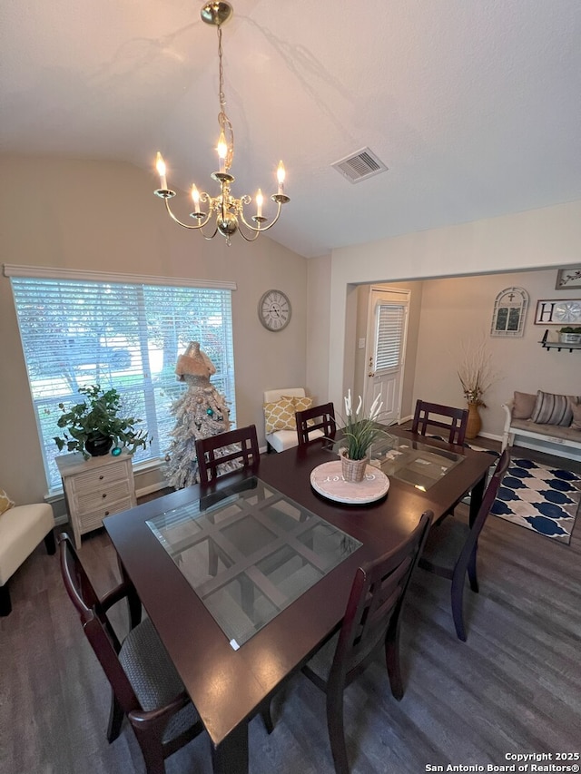 dining room featuring vaulted ceiling, an inviting chandelier, and wood-type flooring