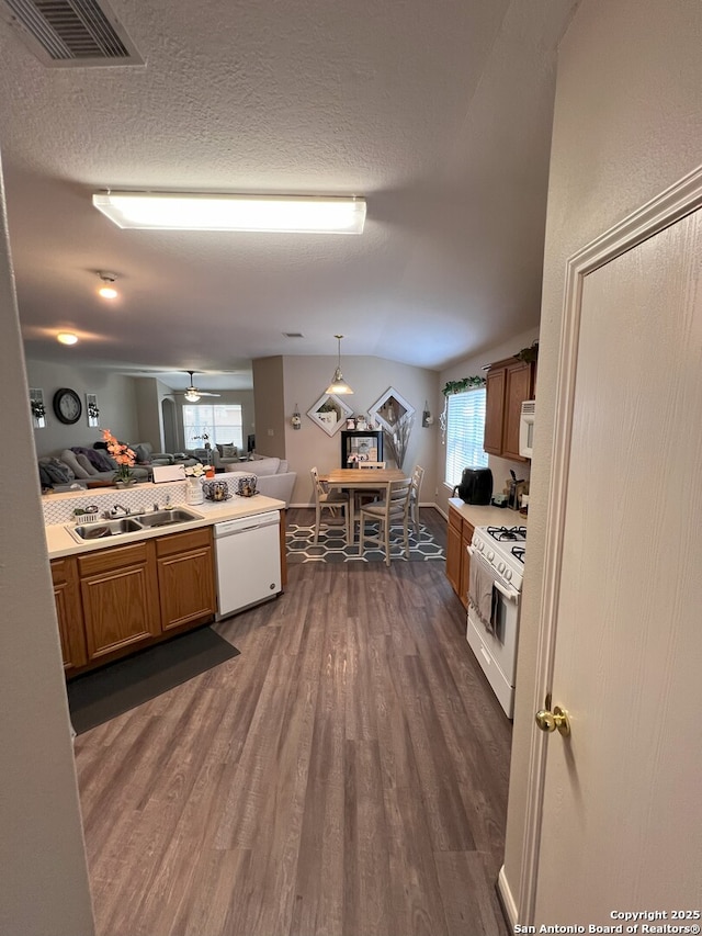 kitchen with white appliances, sink, dark hardwood / wood-style floors, and decorative light fixtures