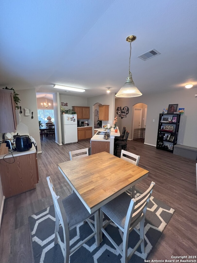 dining space featuring an inviting chandelier and dark hardwood / wood-style flooring