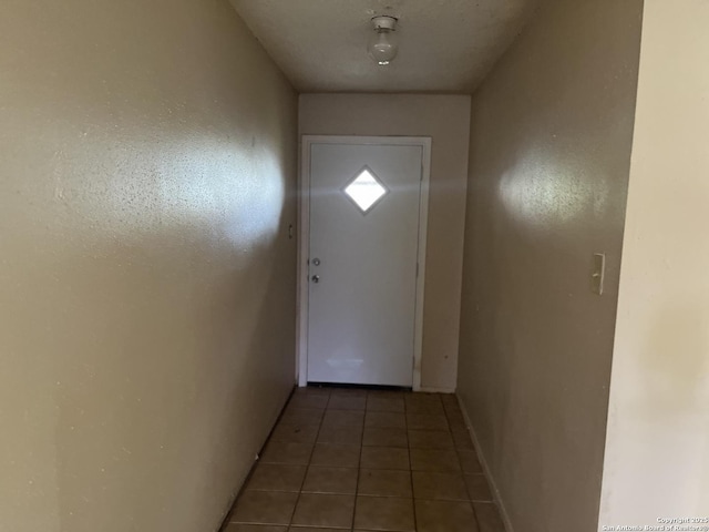 doorway with dark tile patterned floors