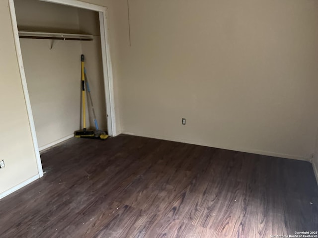 unfurnished bedroom with dark wood-type flooring and a closet