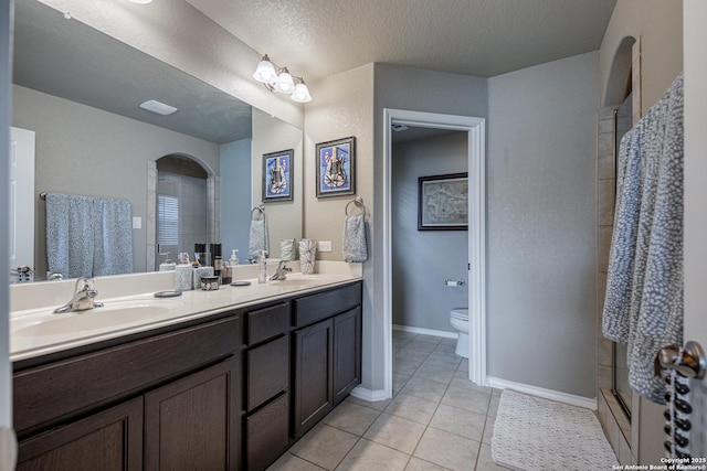 bathroom with a shower with shower door, tile patterned floors, toilet, a textured ceiling, and vanity