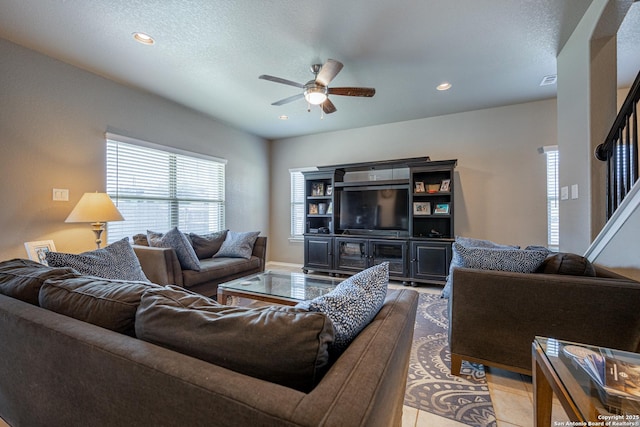 tiled living room featuring ceiling fan and a textured ceiling