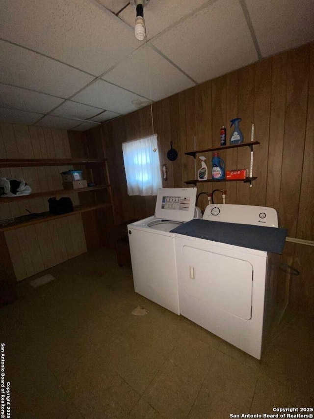 laundry room featuring laundry area, tile patterned floors, wooden walls, and washer and dryer