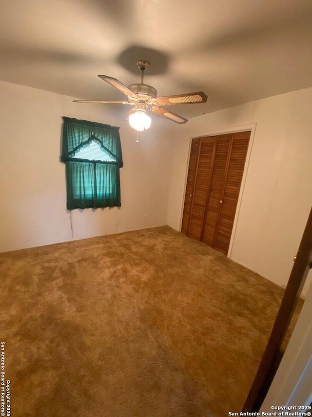 unfurnished bedroom with carpet, a closet, and ceiling fan