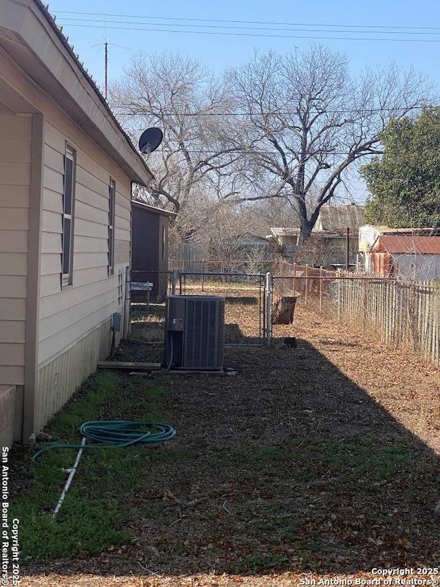 view of yard with fence and central air condition unit