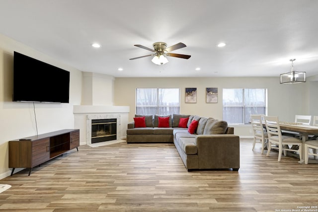 8907 Athens, San Antonio, TX 78251 - living room with ceiling fan with notable chandelier, light wood-type flooring, a wealth of natural light, and a premium fireplace