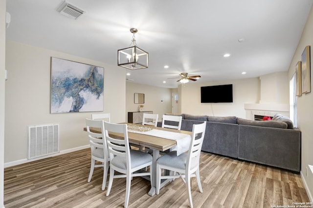 8907 Athens, San Antonio, TX 78251 - dining area with ceiling fan with notable chandelier and light hardwood / wood-style flooring
