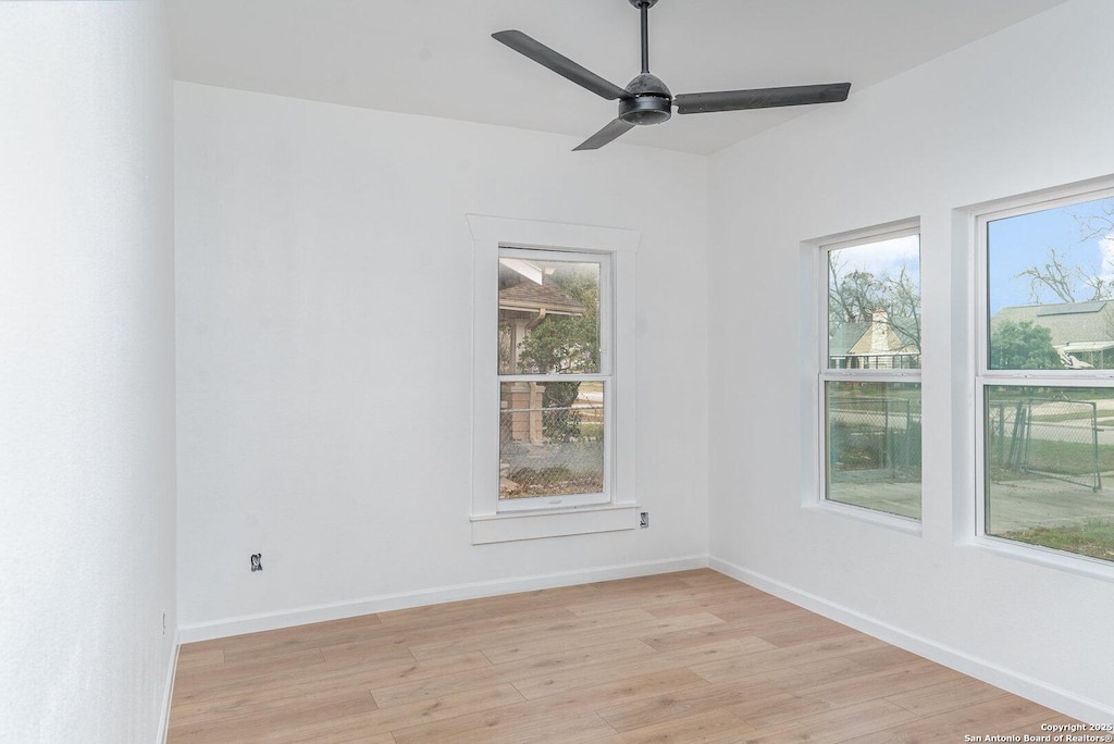 unfurnished room featuring ceiling fan, light hardwood / wood-style floors, and a wealth of natural light